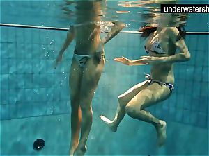 two luxurious amateurs showing their bodies off under water